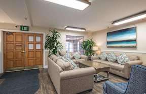 a living room with couches and chairs and a table at Huntington Terrace North Senior, Huntington Beach