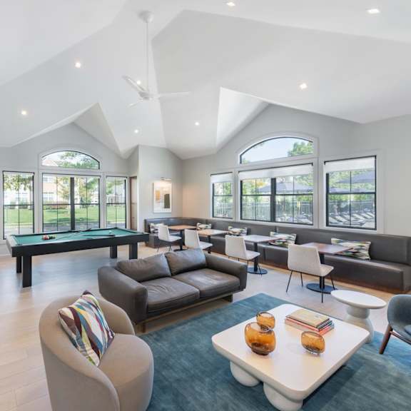 a large living room with a pool table and couches
