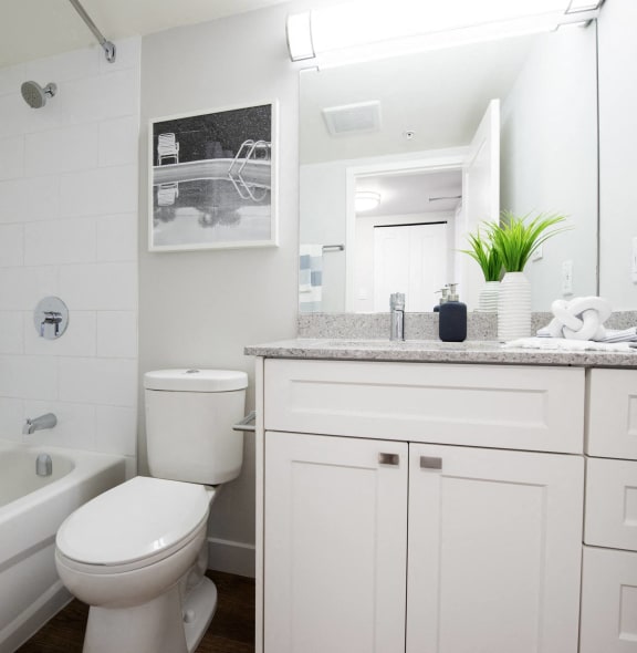 a white bathroom with a toilet and a tub
