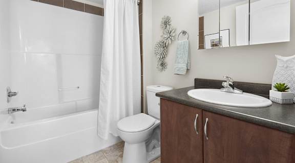 A white bathroom with a toilet, sink, and bathtub.