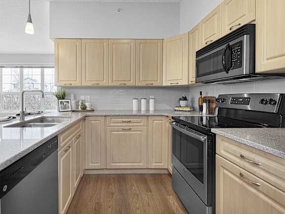 a kitchen with black appliances and white counter tops
