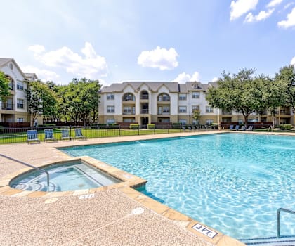 A large swimming pool in front of apartment buildings.