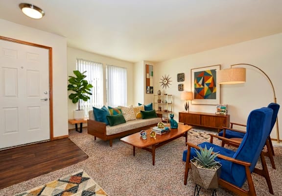 A living room with a blue chair and a wooden bench.