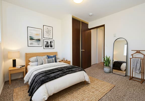 A bedroom with a large bed and a mirror on the wall.