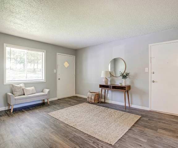A room with a couch, a table, and a mirror.