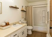 Thumbnail 7 of 8 - A bathroom with a white sink and a white toilet.