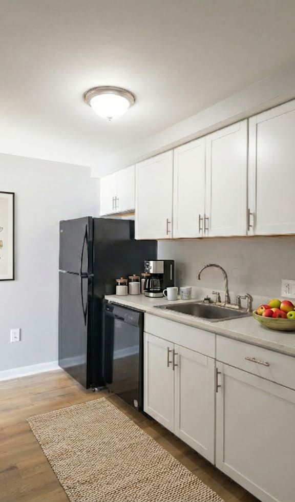 A kitchen with a white counter and black stools.