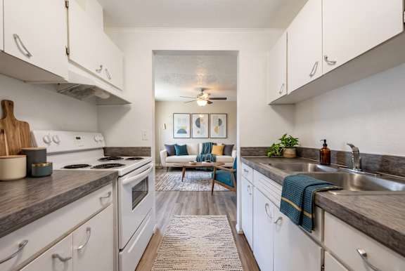 A kitchen with white cabinets and a rug on the floor.
