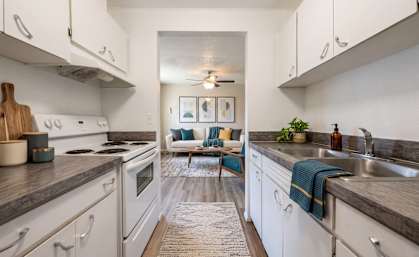 A kitchen with white cabinets and a rug on the floor.