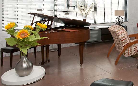A living room with a piano, chairs, and a couch.