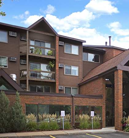 an apartment building with a red brick facade and a parking lot  at Park Pointe, St. Louis Park, 55426