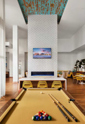 a large living room with a pool table and a fireplace at The District at Rosemary, Sarasota, FL, 34236