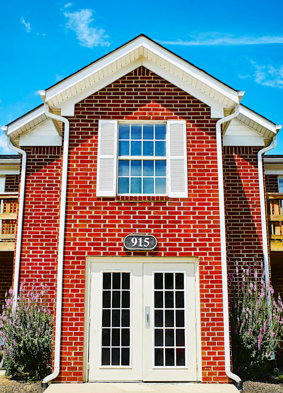 a red brick house with a white door and window