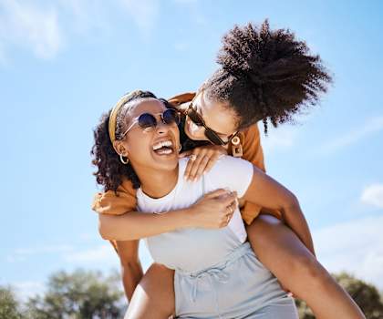 two women wearing sunglasses are laughing and having fun on a sunny day  at Barcelona Jupiter, Jupiter, 33458