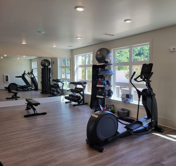 a gym with exercise machines and windows