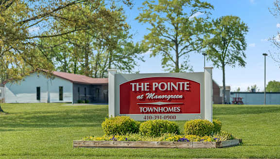 A sign for The Pointe at Meadowcreek is displayed in front of a building.