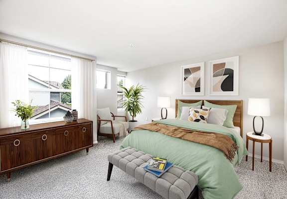 A bedroom with a large bed and a window overlooking a house.