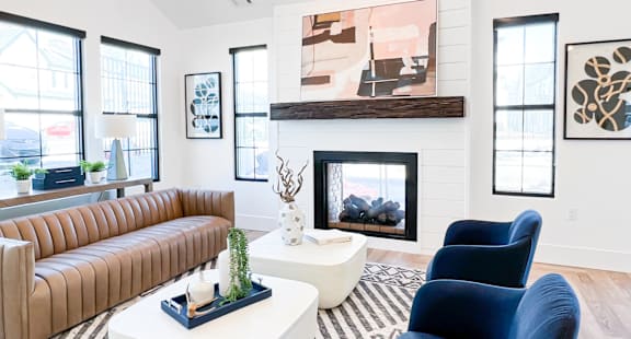 A living room with a fireplace and a painting above it.