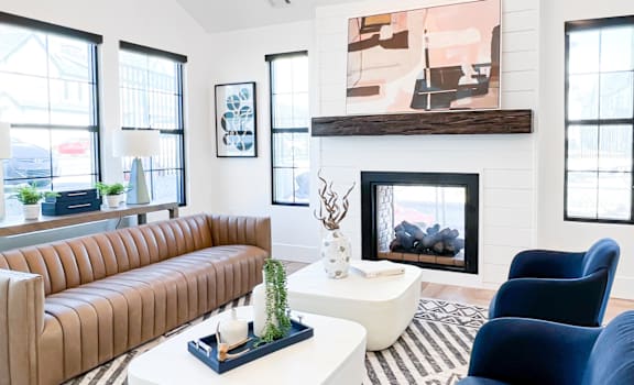 A living room with a fireplace and a painting above it.