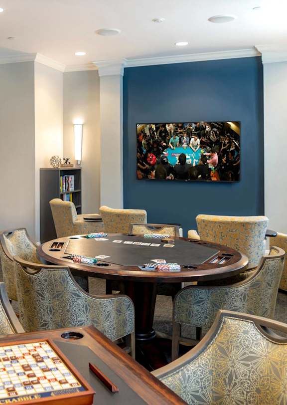 A room with a table, chairs, and a painting on the wall.