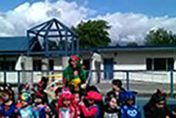 A group of children are standing in front of a building.