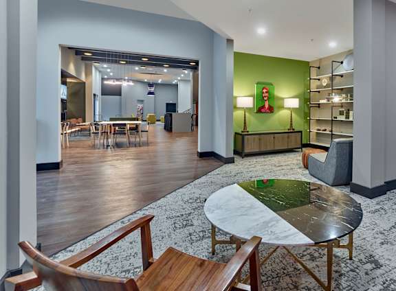 A modern living room with a green accent wall and a coffee table in the center at Cityplace Apartment Homes Apartments, Allentown, PA, 18101