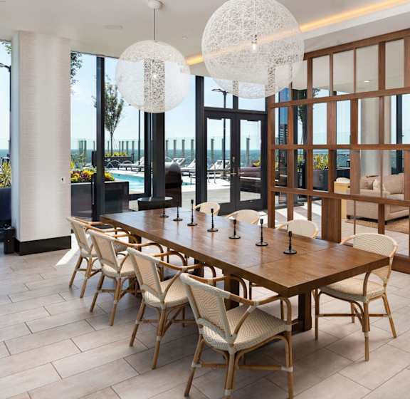 A modern dining room with a long wooden table and chairs at 903 Peachtree in GA 30309