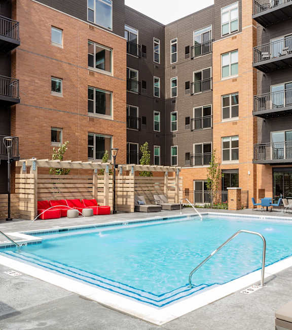 A swimming pool in front of apartment buildings.