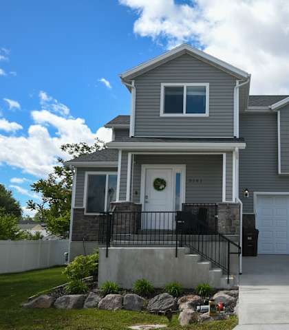 a gray house with a driveway and a garage door