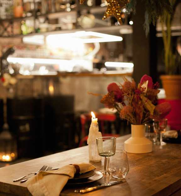 A table set for a meal with a candle and flowers.