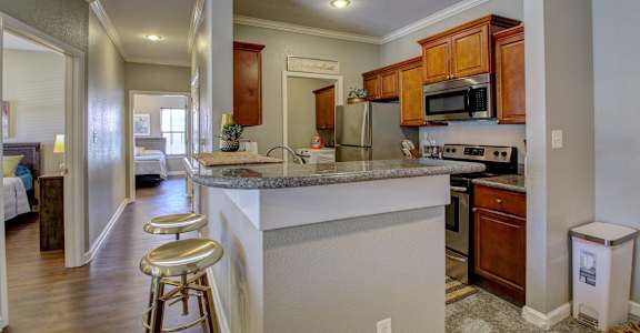 A kitchen with a white counter top and wooden cabinets.