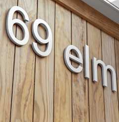 A wooden wall with the number 69 and the word elm on it.