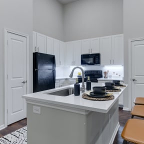 a kitchen with a large island with granite countertops