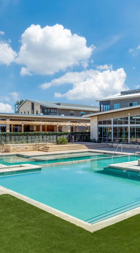 a large swimming pool with a building in the background