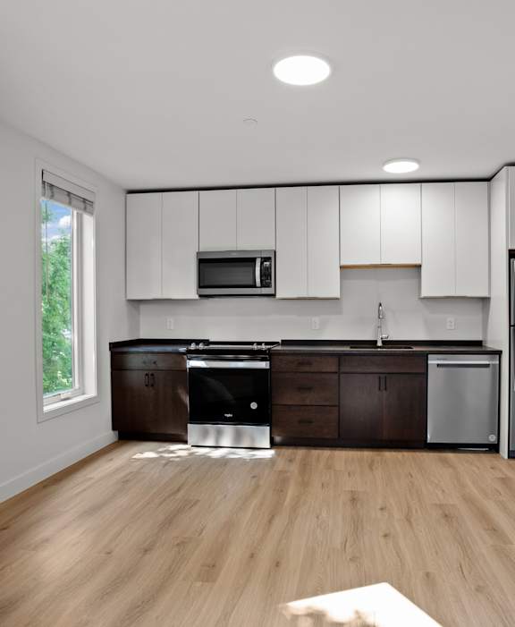 A kitchen with wooden floors and stainless steel appliances.