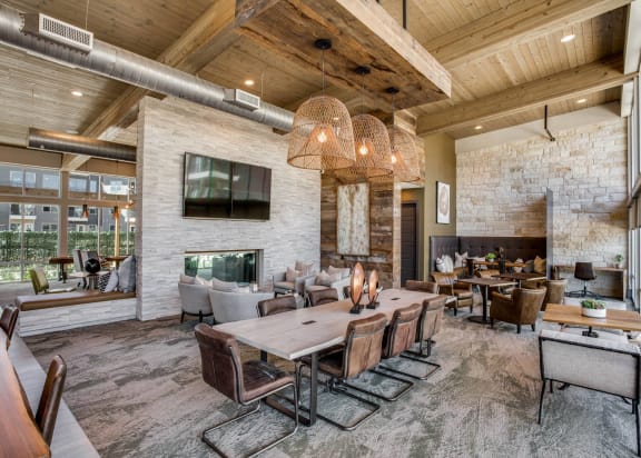 a large living room with a large table and chairs and a fireplace