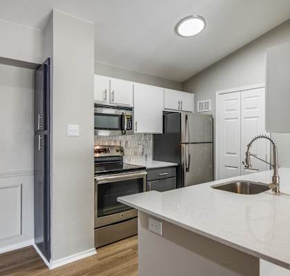 a kitchen with white cabinets and stainless steel appliances