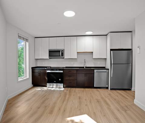 A kitchen with wooden floors and stainless steel appliances.