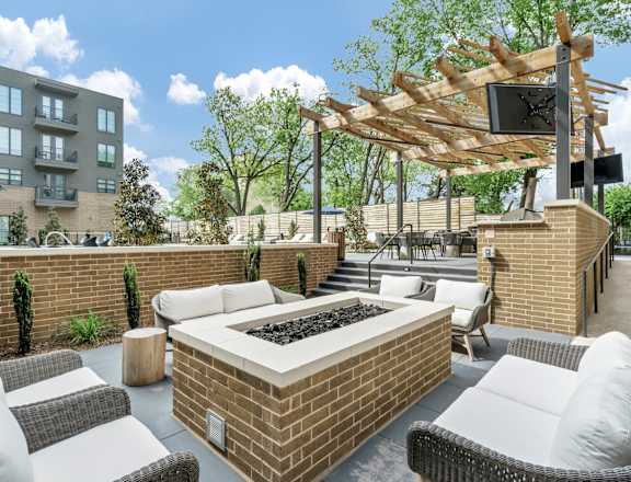 A patio with a fire pit and seating area.