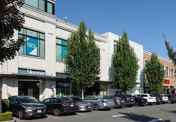 A row of cars are parked in front of a building with a blue sign that says "track".