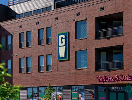 A red brick building with a green sign that says GW on it.