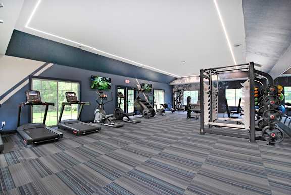 A gym with treadmills, weights, and exercise equipment.