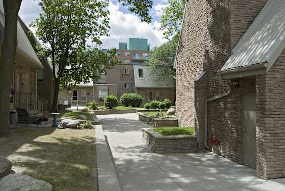 a courtyard with a sidewalk and a building in the background
