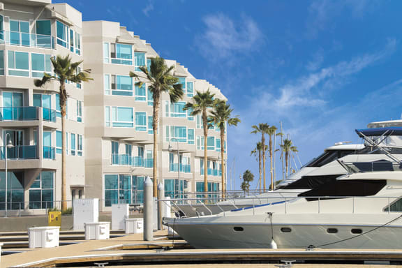 a group of boats parked in front of a building with palm trees at Esprit Apartments, Marina del Rey, CA, 90292