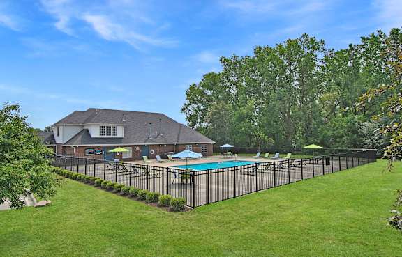 Clubhouse with a pool and a fence.
