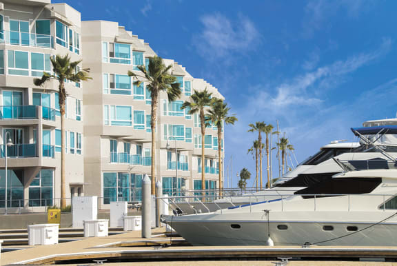 a group of boats parked in front of a building with palm trees  at Esprit Apartments, Marina del Rey, 90292