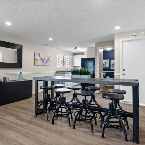 A modern kitchen with a black countertop and bar stools.