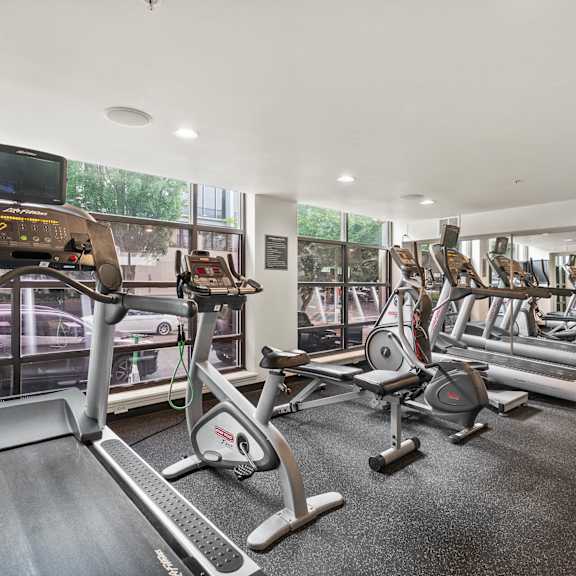 A gym with treadmills, exercise bikes, and other equipment.