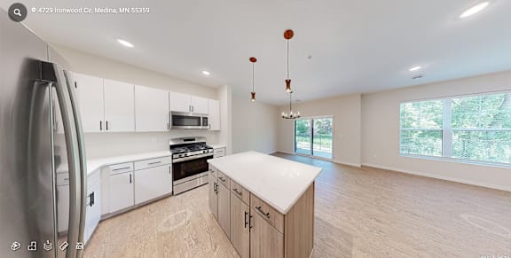 A modern kitchen with wooden floors and white cabinets.