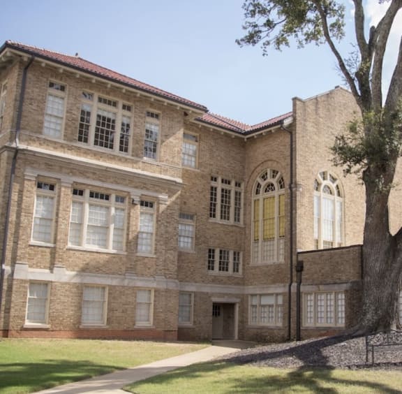 a large brick building with a tree in front of it